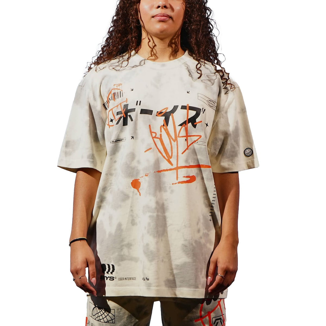 Person wearing a beige t-shirt with graphic designs on a white background